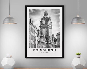 May include: Black and white photograph of a clock tower in Edinburgh, Scotland. The clock tower is tall and has a pointed roof. The photo is framed in a black frame.