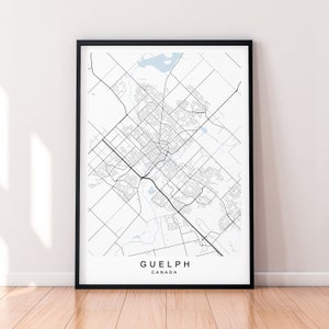 May include: A black and white map print of Guelph, Canada. The map shows the city's streets and landmarks. The city name is printed at the bottom of the map.
