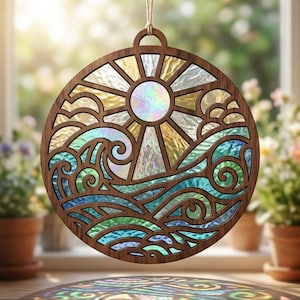 May include: A circular wooden suncatcher featuring a laser-cut frame with an intricate design of a sun and ocean waves. The interior sections are filled with iridescent, textured glass panels in shades of blue, green, and yellow.