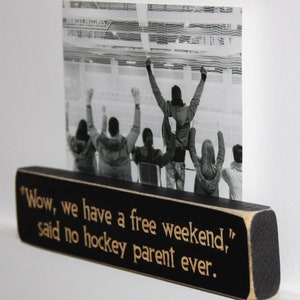 May include: Black wooden sign with white text that reads "Wow, we have a free weekend," said no hockey parent ever."