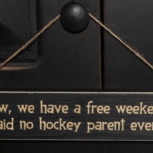 May include: A black wooden sign with white text that reads "Wow, we have a free weekend," said no hockey parent ever."