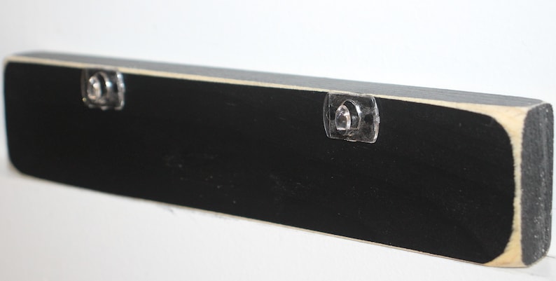 May include: Black wooden sign with two clear plastic hanging hooks on the back.
