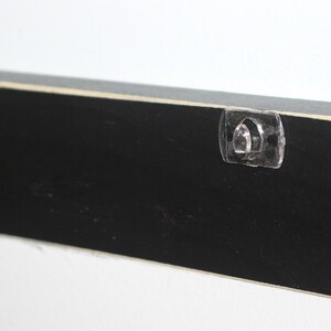May include: Black wooden sign with two clear plastic hanging hooks on the back.