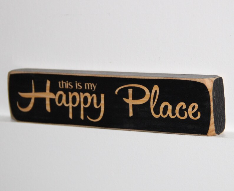 May include: Black wooden sign with the text "this is my Happy Place" in a light wood color.