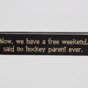 May include: Black wooden sign with the text "Wow, we have a free weekend," said no hockey parent ever."