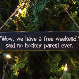 May include: A black wooden sign with white text that reads "Wow, we have a free weekend," said no hockey parent ever."