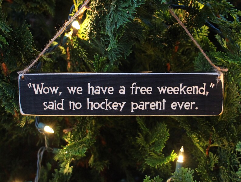 May include: A black wooden sign with white text that reads "Wow, we have a free weekend," said no hockey parent ever."