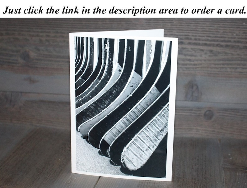 May include: Black and white photograph of a stack of hockey sticks, arranged in a pattern, with the grain of the wood visible.