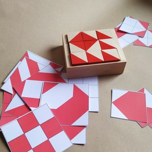 Puede incluir: Una caja de madera con un patr&oacute;n geom&eacute;trico rojo y blanco hecho de bloques de madera. La caja est&aacute; abierta y los bloques son visibles. Tambi&eacute;n hay varias formas geom&eacute;tricas rojas y blancas sobre una superficie marr&oacute;n.