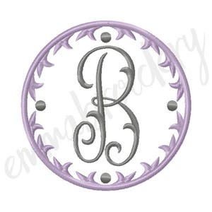 Puede incluir: Una inicial de monograma "B" en color gris plateado está centrada en un círculo con un diseño floral morado.
