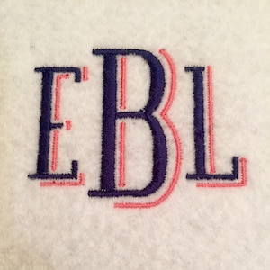 May include: Embroidered monogram with the letters E, B, and L. The letters are outlined in pink and filled in with navy blue.