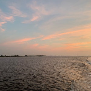 Sunset over the Cape Fear River With Oak Island Lighthouse in the distance