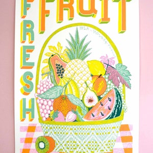 May include: A colorful illustration of a basket overflowing with fresh fruit. The basket is filled with a variety of fruits, including pineapple, papaya, watermelon, grapes, lemons, and figs. The text "FRESH FRUIT" is written in large, bold letters above the basket. The text "ISLA..." is written in smaller letters below the basket.