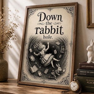 Puede incluir: Una impresión enmarcada con el texto "Down the rabbit hole." presenta una ilustración en blanco y negro de Alicia cayendo en una madriguera de conejo, rodeada de naipes y un conejo. La impresión está en un marco de madera marrón.