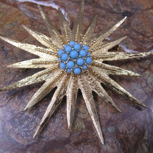 Beautiful gold plated sunburst brooch with a cluster of faux turquoise beads in the centre