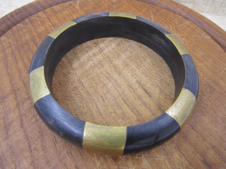 Beautiful artisan bangle in black with shiny brass strips