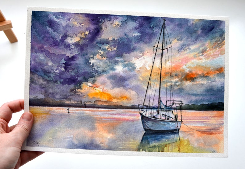 May include: Watercolor painting of a sailboat on a calm body of water at sunset. The sky is a mix of purple, orange, and yellow with fluffy clouds. The water reflects the colors of the sky.