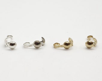 May include: Three silver, nickel, and gold tone metal earring clasps. Each clasp has a small round ball on the end.