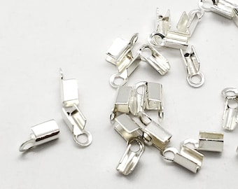 May include: A group of silver-toned metal crimp beads, used for jewelry making.