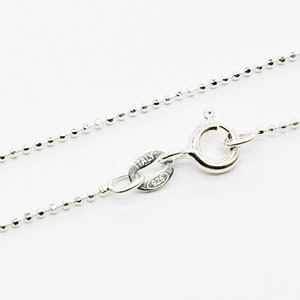 Puede incluir: Un collar de cadena de plata con estilo de cadena de bolas. La cadena tiene un cierre de langosta y una etiqueta que dice "ITALY 925".