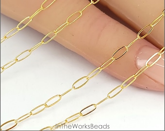 May include: Gold-toned oval chain, a type of jewelry chain, shown in a close-up image. The chain is laid out in rows on a hand, showing the size and shape of the links.