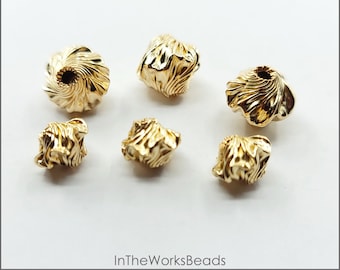 May include: Six gold-filled twisted corrugated garlic beads in two sizes. The beads have a textured, ridged surface and are made in the USA.