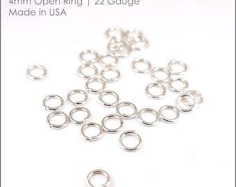 May include: A pile of 22 gauge sterling silver open jump rings, each measuring 4mm in diameter. The rings are made in the USA.