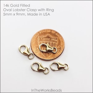 May include: Three gold-filled oval lobster clasps with rings, each measuring 5mm by 9mm. The clasps are shown next to a US penny for size comparison.