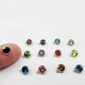Puede incluir: Surtido de 14 abalorios de tono dorado con piedras preciosas redondas y facetadas en varios colores, incluyendo negro, verde, azul, morado, rojo, rosa y transparente.