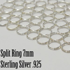 Puede incluir: Primer plano de un montón de anillos partidos de plata, cada uno con un diámetro de 7 mm. Los anillos son de plata de ley, marcados con .925.  Anillo partido 7mm Plata de ley .925