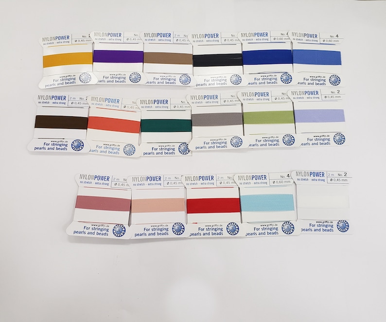 May include: Assortment of 2 meter spools of nylon thread in various colors, labeled "NYLONPOWER" for stringing pearls and beads. The spools are arranged in rows on a white surface.