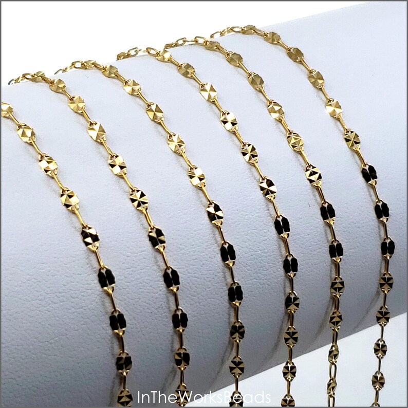 May include: Gold chain with a faceted oval link design. The chain is shown in multiple lengths.