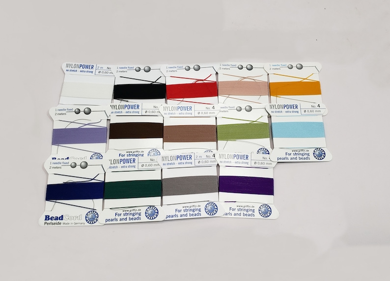 May include: Assortment of Nylon Power beading thread spools in various colors. Each spool is labeled with the brand name, thread size, and length. The spools are arranged in rows on a white background.