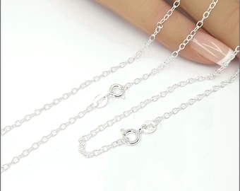 May include: A silver chain necklace with a lobster clasp and a jump ring. The chain is made of small, oval-shaped links.