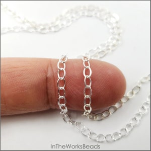 May include: Two silver chains of different sizes, shown on a finger to illustrate the difference in thickness.