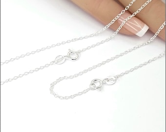 May include: A silver chain necklace with two lobster clasps. The chain is made of small, round links.