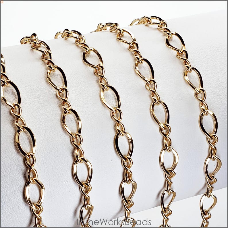 14k gold filled figure 8 flat curb chain draped on bracelet bar. Features 5.5mm x 8.6mm oval links and 3mm x 8.5mm figure 8 connectors. Constructed with 19 gauge wire.