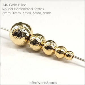May include: Five gold-filled round hammered beads in various sizes, 3mm, 4mm, 5mm, 6mm, and 8mm, strung on a wire. 14K Gold Filled Round Hammered Beads.