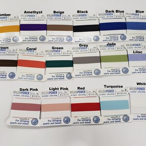 May include: A collection of 16 spools of nylon thread in various colors, labeled with the brand name "NYLONPOWER" and the text "For stringing pearls and beads".