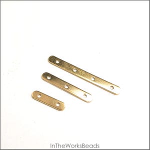May include: Three gold-colored metal connector bars of varying lengths, each with evenly spaced holes for attaching to other components. The bars are arranged diagonally against a white background. The text "InTheWorksBeads" is at the bottom.