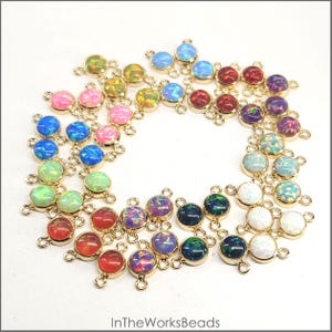 May include: Assortment of 24 opal gemstone connector charms with gold-tone double loop settings. The charms are in various colors, including white, blue, green, red, pink, and purple.