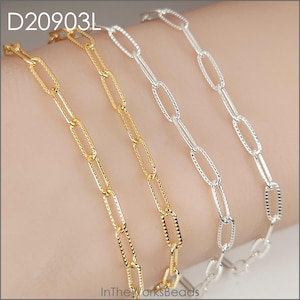 May include: Close-up of gold and silver chain bracelets. The bracelets have an oval link design. The gold chains have a textured pattern. The text "D20903L" is in the upper left corner. The text "InTheWorksBeads" is in the bottom center.