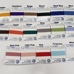 May include: A collection of 16 spools of nylon thread in various colors, labeled with the brand name "NYLONPOWER" and the text "For stringing pearls and beads".