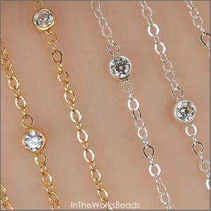 May include: Close-up of several delicate necklaces. The necklaces feature small, clear gemstones set in gold and silver chains. The chains have an oval link design. The image is well-lit, highlighting the sparkle of the gemstones. The text "InTheWorksBeads" is visible at the bottom.