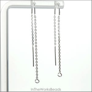 May include: A pair of silver chain earrings with a simple, minimalist design. The earrings are made of a delicate chain and have a small loop at the bottom.