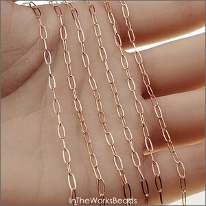 May include: Multiple strands of gold-toned oval chain, shown on a hand. The chain is a popular choice for jewellery making.