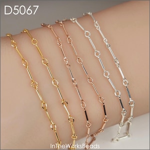 May include: Five delicate bracelets in gold, rose gold, and silver tones. Each bracelet features a chain design with small, connected bars and circular links. The bracelets are displayed on a wrist, showcasing their different metallic finishes. The text "D5067" and "InTheWorksBeads" are visible.