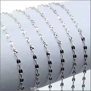 May include: Silver chain with a faceted oval link design. The chain is shown in multiple lengths.