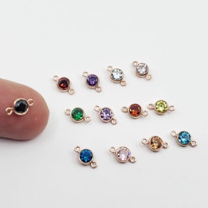 May include: Assortment of 12 rose gold connector charms with different coloured crystal stones. Each charm has two loops for attaching to jewellery.
