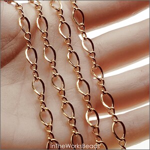 14k gold filled 5.5mm x 8.6mm figure 8 flat curb chain displayed on hand model. Oval links measure 5.5mm x 8.6mm and figure 8 connectors are 3mm x 8.5mm. Chain made from 19 gauge wire.